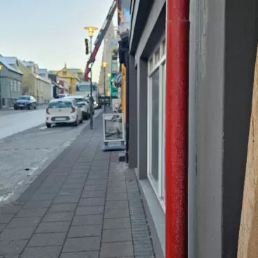 Stadtstraße mit bunten Gebäuden und einem Holzschild mit der Aufschrift „WORKSHOP“ 